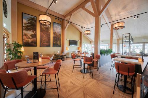 a restaurant with tables and chairs and a bar at Boutique Hotel het Witte Veen in Witteveen