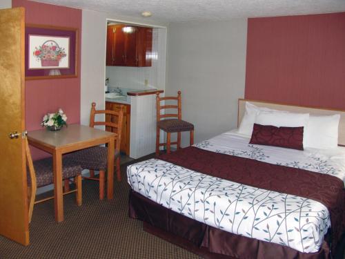 a hotel room with a bed and a table and a kitchen at Inn at Salmon Creek in Vancouver