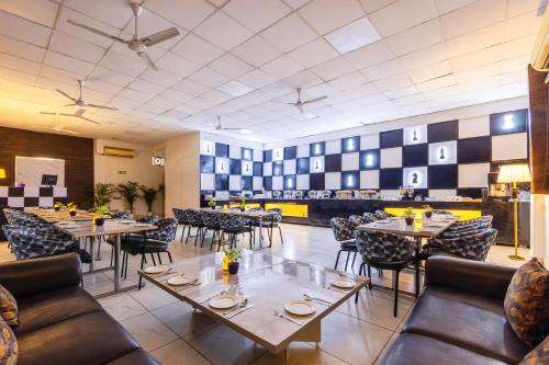 a dining room with tables and chairs in a restaurant at Aliste Millennium Huda City Centre in Gurgaon