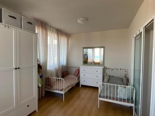 Una habitación con dos cunas, una cómoda y un espejo. en Sea View Apartment in Byala, en Byala