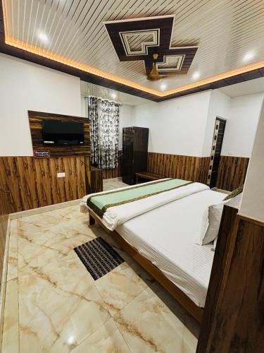 a bedroom with a bed and a flat screen tv at S R Hotel in Varanasi