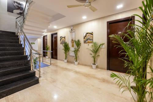 a lobby with potted plants and a staircase at Aliste Millennium Huda City Centre in Gurgaon