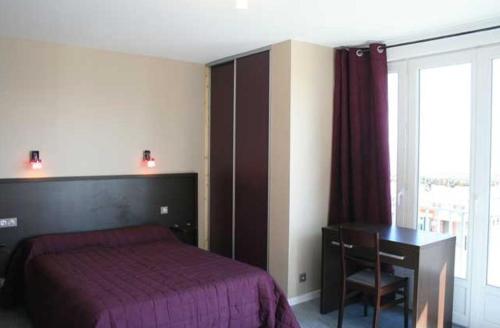 1 dormitorio con cama, escritorio y ventana en Hotel Le Richelieu en Le Tréport
