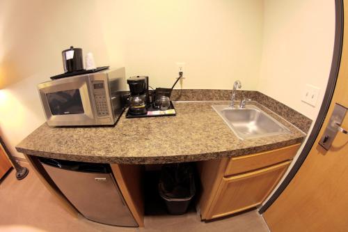 a kitchen counter with a microwave and a sink at Quality Inn Selah North Park in Selah