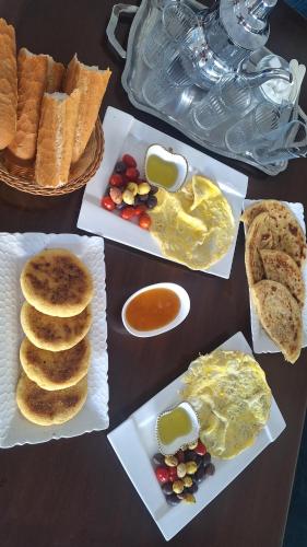 a table topped with plates of food with eggs and bread at Chambres au sein d'une villa in Rabat