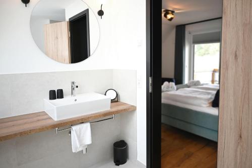 a bathroom with a sink and a mirror and a bed at Pidder-Lyng Haus 3 in Böhl