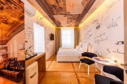 a room with a bed and a table and chairs at Small Luxury Hotel Goldgasse in Salzburg