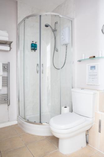 a white bathroom with a shower and a toilet at The Two Lifeboats in Sheringham