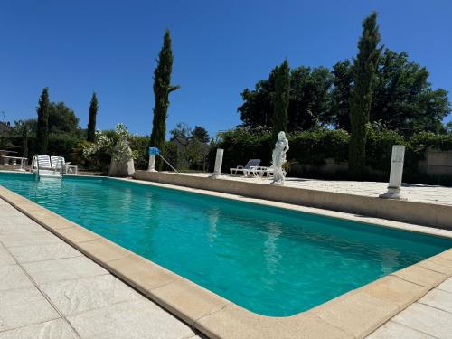 a swimming pool with blue water in a yard at Le Relais St trop - Villa 2 chambres Delon et Romy in Bressolles