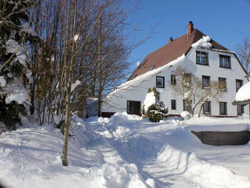 a white house with a pile of snow in front of it at Wohnung in Lauterbach nahe Skipisten in Lauterbach
