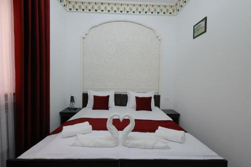 a bed with two white swans forming a heart at RAY Boutique Hotel in Bukhara