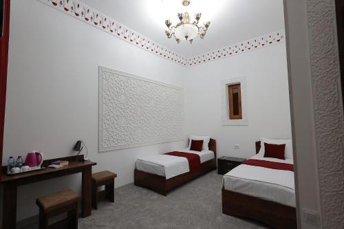 a hotel room with two beds and a chandelier at RAY Boutique Hotel in Bukhara