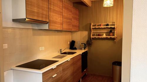 a kitchen with a sink and a counter top at Le Gite de Solutré Parking Terrasse Cosy in Solutré-Pouilly