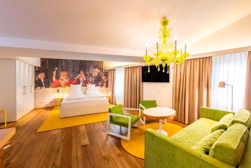 a living room with a couch and a chandelier at Small Luxury Hotel Goldgasse in Salzburg