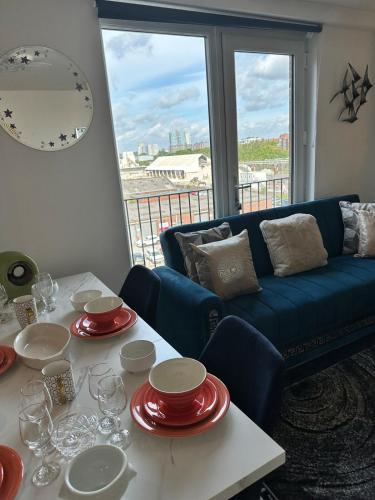 a living room with a blue couch and a table with wine glasses at Mega3 Central Manchester Luxury 2-Bedroom,2-Baths with Free Car Park in Manchester