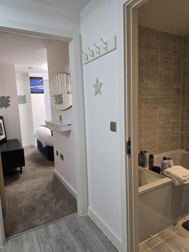 a room with a bathroom with a bed and a mirror at Mega3 Central Manchester Luxury 2-Bedroom,2-Baths with Free Car Park in Manchester