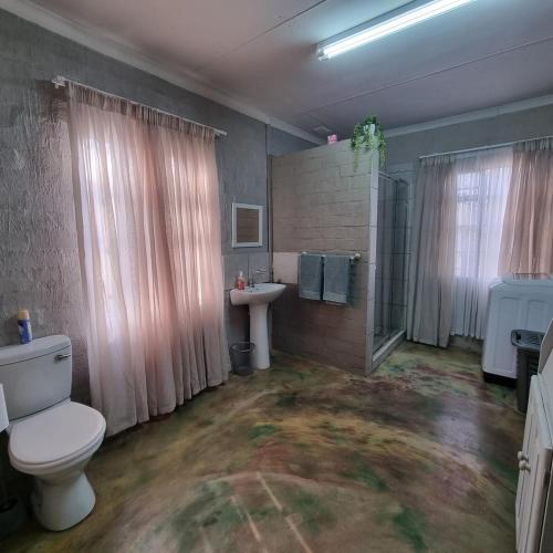 a bathroom with a toilet and a sink at Onse Boshuis in Marloth Park