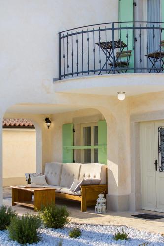 a couch sitting on a patio under a building at Villa Luca with pool and jacuzzi in Vrh