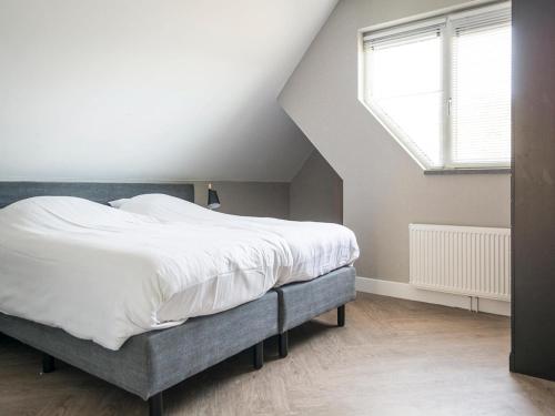a bedroom with a large bed and a window at Luxurious villa for 8 people in De Cocksdorp Texel in De Cocksdorp