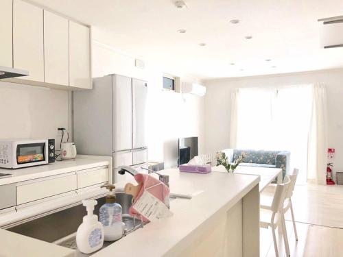 a kitchen with white cabinets and a counter top at Putao in Osaka