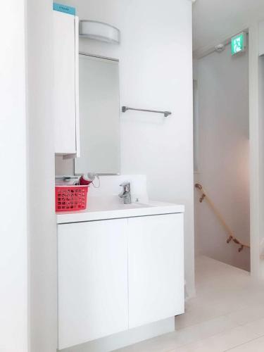 a white kitchen with a sink and a red basket at Putao in Osaka