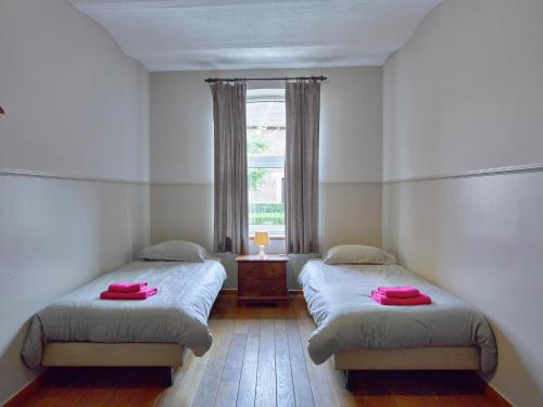 two beds in a room with a window at Monastery Retreat in Blossoming Limburg in Sint-Truiden