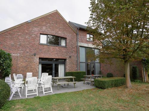 a brick building with white chairs and a table at Monastery Retreat in Blossoming Limburg in Sint-Truiden