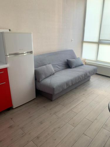 a bed in a room with a refrigerator at Apartment in Odesa Akvarel in Odesa