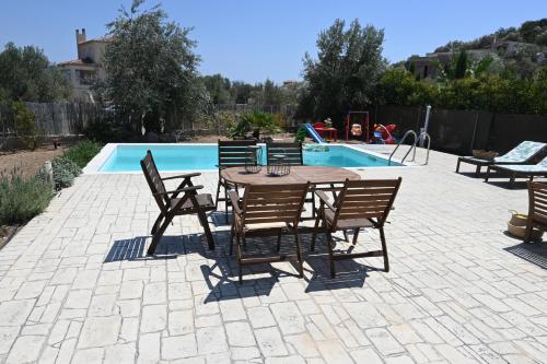 a patio with a table and chairs next to a pool at Villa Elaida in Ermioni
