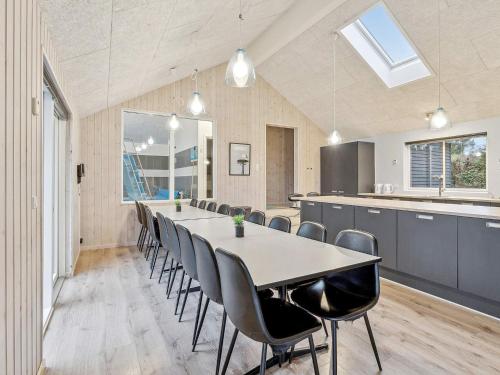an open kitchen and dining room with a long table and chairs at Luxury Pool Retreat - By Traum Ferienwohnungen in Vejby