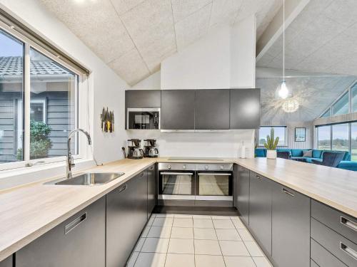 a kitchen with stainless steel cabinets and a large window at Luxury Pool Retreat - By Traum Ferienwohnungen in Vejby