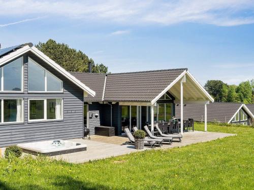 a house with a deck and chairs in the yard at Luxury Pool Retreat - By Traum Ferienwohnungen in Vejby