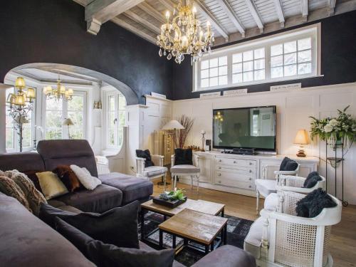 een woonkamer met een bank en een tv bij Holiday Home in Koksijde near Beach in Koksijde