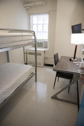 a room with a bunk bed and a desk with a computer at West Side YMCA in New York