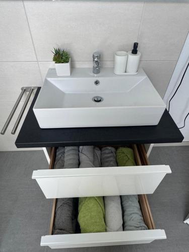 a bathroom vanity with a sink and towels at Waldzauber - Moderne Ferienwohnung im Grünen in Elpenrod