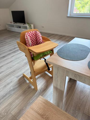 a chair and a table in a living room at Waldzauber - Moderne Ferienwohnung im Grünen in Elpenrod