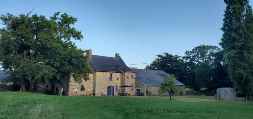 an old brick house with a large grass field at Séjour à la campagne in Crévin