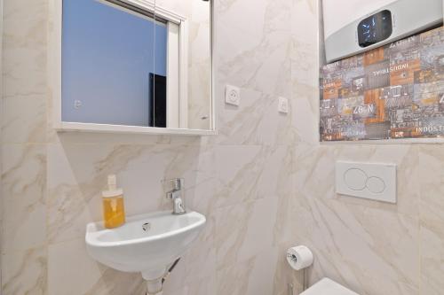 une salle de bain blanche avec un lavabo et un miroir dans l'établissement 2 Bedroom Apartment Île Saint-Louis With Free Netflix, à Paris