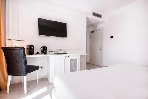 a white room with a desk and a television on a wall at Ludwig Boutique Hotel & Spa in Bolsena