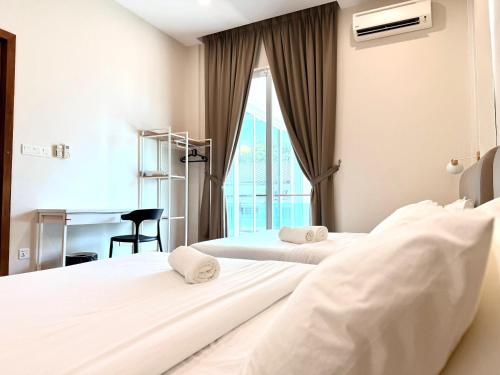 two beds in a hotel room with a desk at myRoom at 11, Jalan Adams Georgetown in George Town