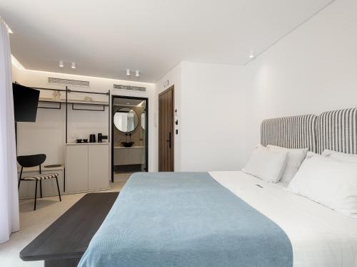 a bedroom with a large bed with a blue blanket at Theta Boutique Hotel in Chania