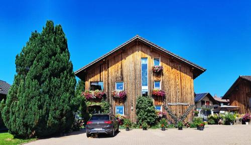 a car parked in front of a wooden building at Haus Vögel in Sibratsgfäll
