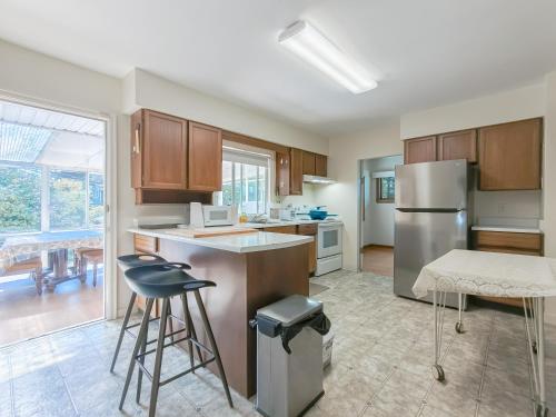 a kitchen with a stainless steel refrigerator and a table at Cozy Airb&b Suite in South Vancouver in Vancouver