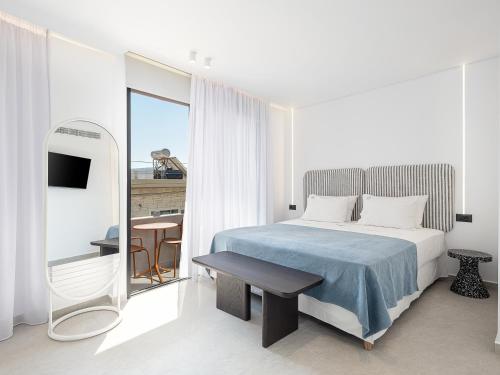 a bedroom with a bed and a table and a mirror at Theta Boutique Hotel in Chania