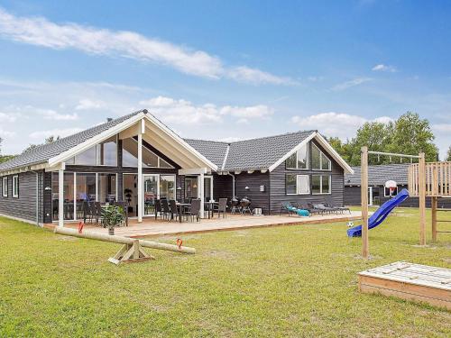 uma casa com escorrega e um parque infantil em 16 person holiday home in Vejby em Vejby