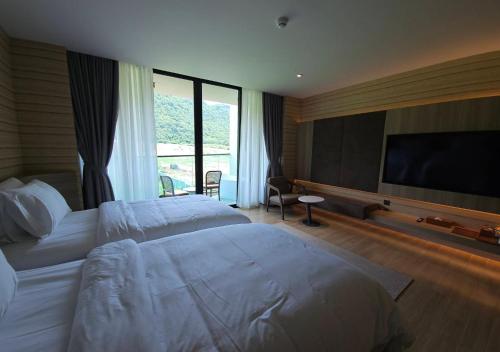 a hotel room with two beds and a flat screen tv at Viewpoint Khaoyai Hotel in Mu Si