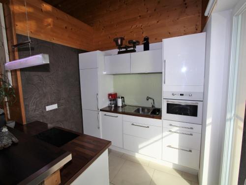 a kitchen with white cabinets and a sink at Apartment in Treffen near Gerlitzen Ski Slopes in Stöckelweingarten