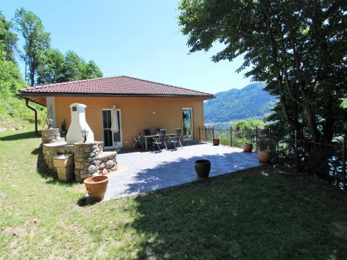 a house with a patio with a table and chairs at Apartment in Treffen near Gerlitzen Ski Slopes in Stöckelweingarten