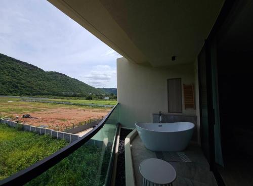 a bathroom with a tub and a view of a field at Viewpoint Khaoyai Hotel in Mu Si