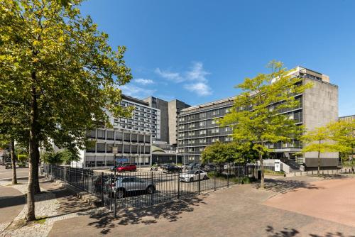 a building with cars parked in front of it at Pullman Eindhoven Cocagne in Eindhoven